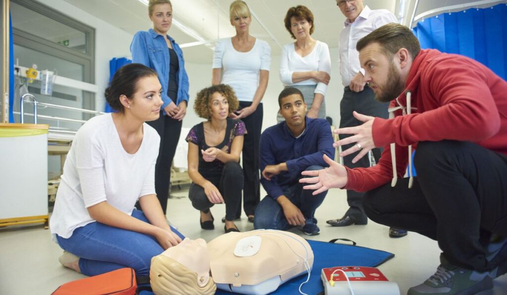 CPR training class instructor teaching a class with a dummy