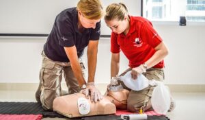 two people practicing on a cpr dummy