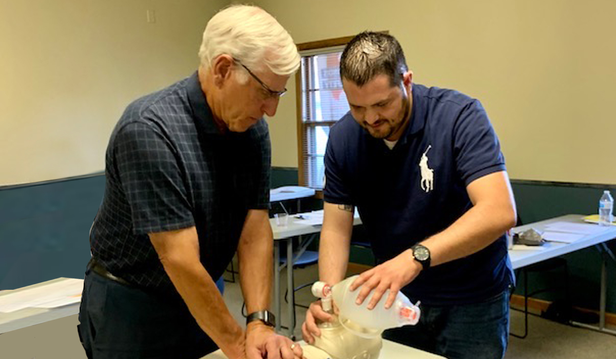 one man is performing CPR on a CPR doll, while the other is pumping the bag valve mask
