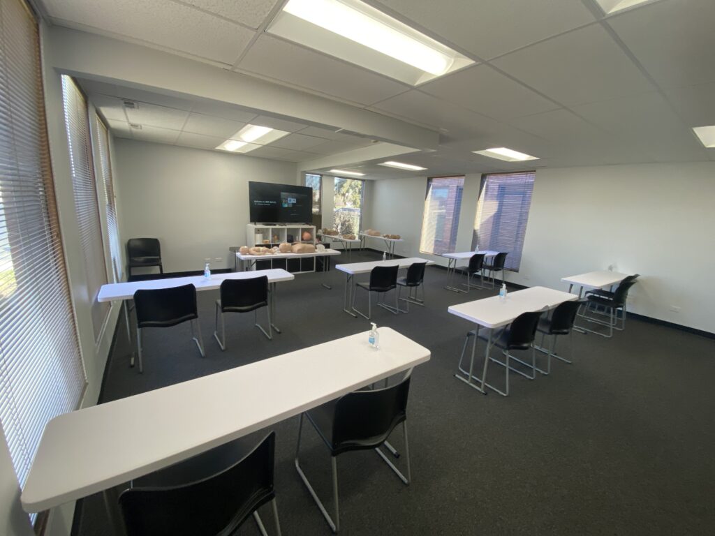 A training room for CPR classes with empty seats and tables