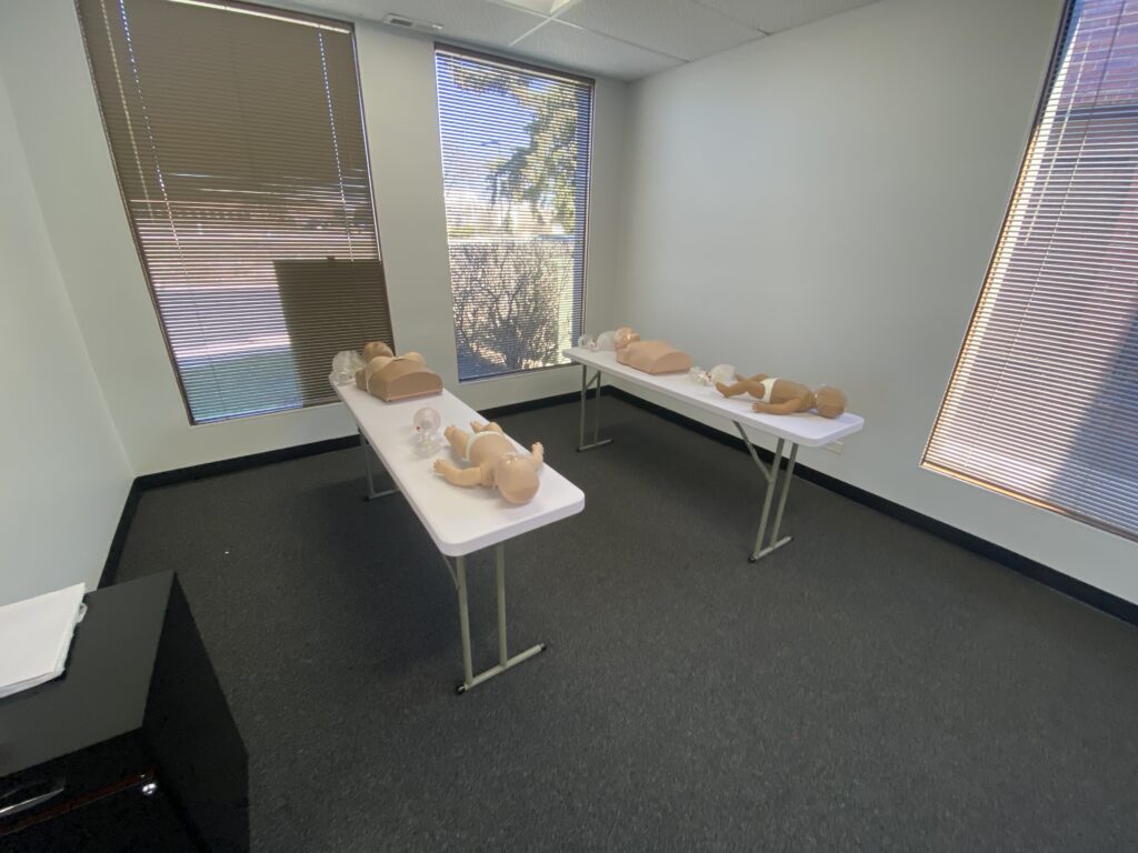 A CPR training room with dummies on the table