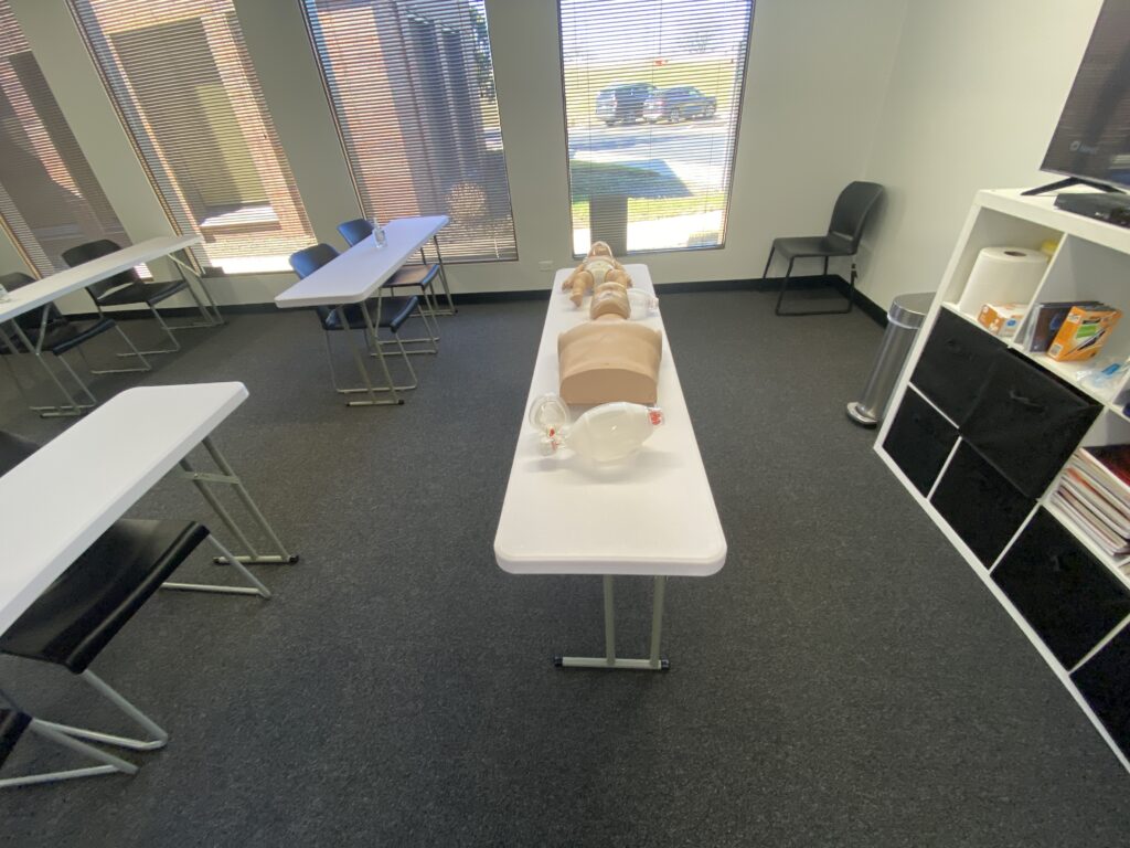 A CPR training room with dummies on the table