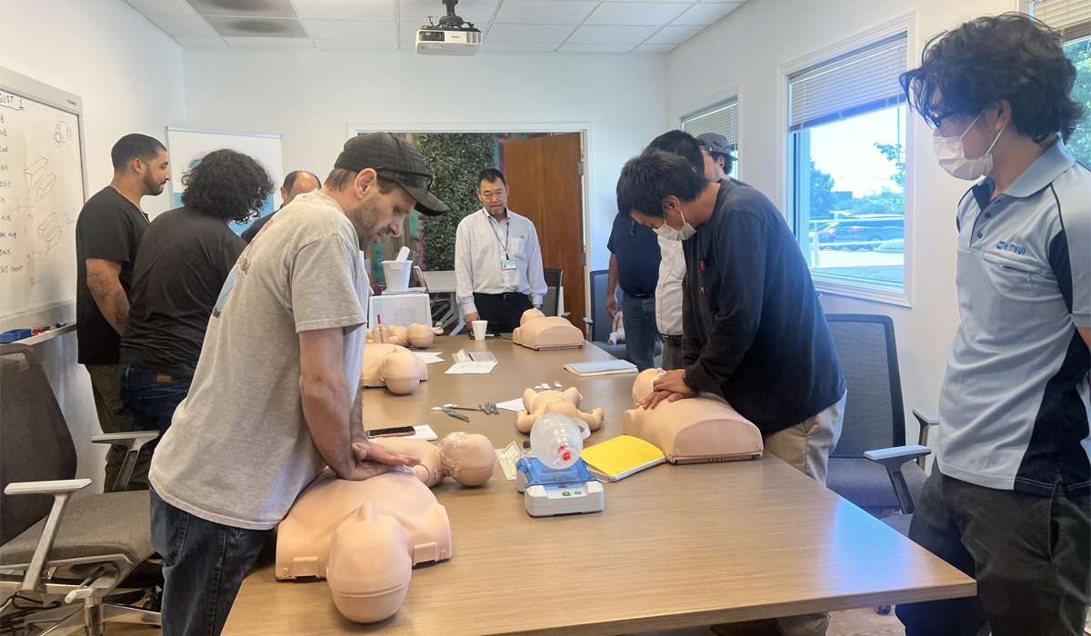 a group of people in a room practicing CPR on dummies