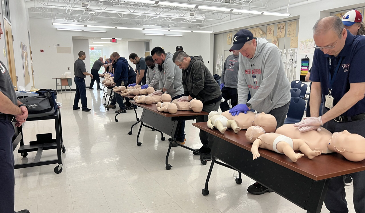 a group of people training CPR on CPR dummies