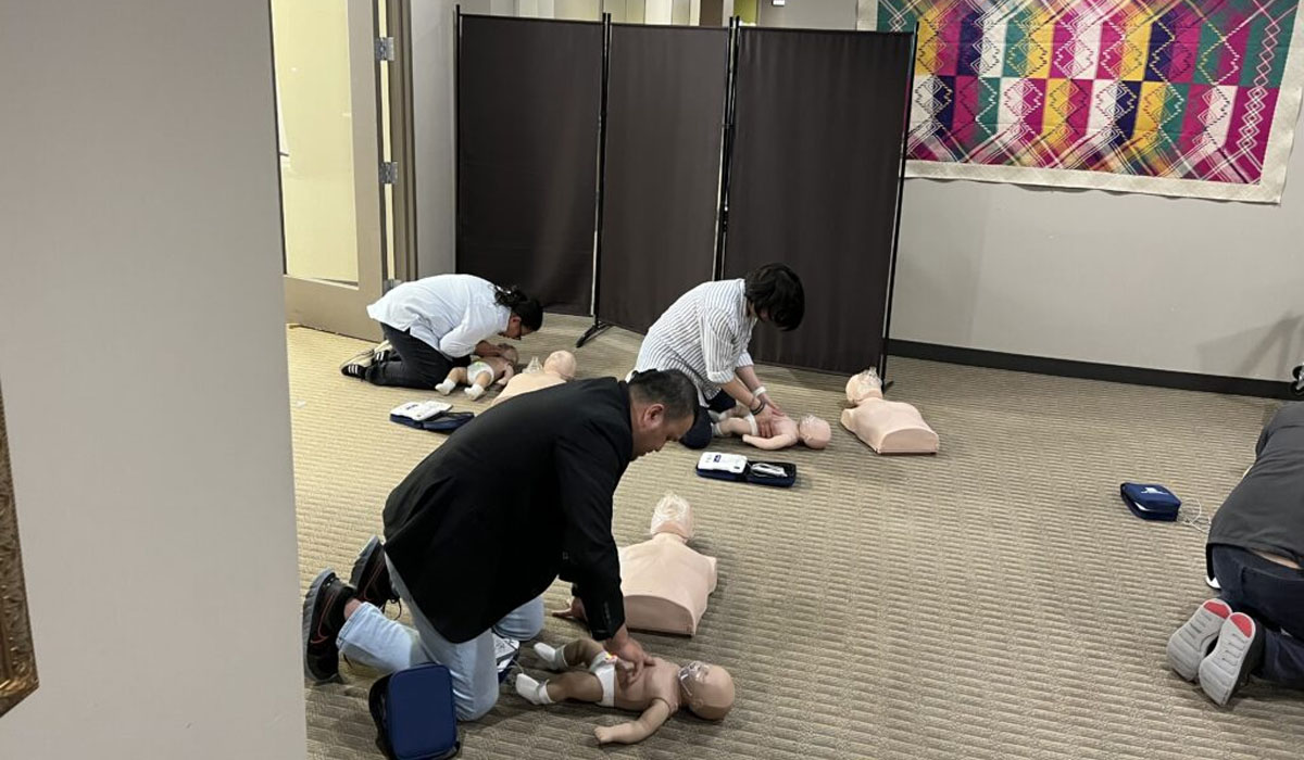 three people training in CPR