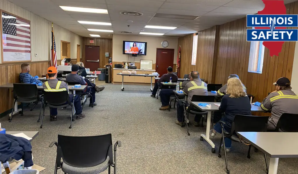 A group of professional workers in a room having training about safety.