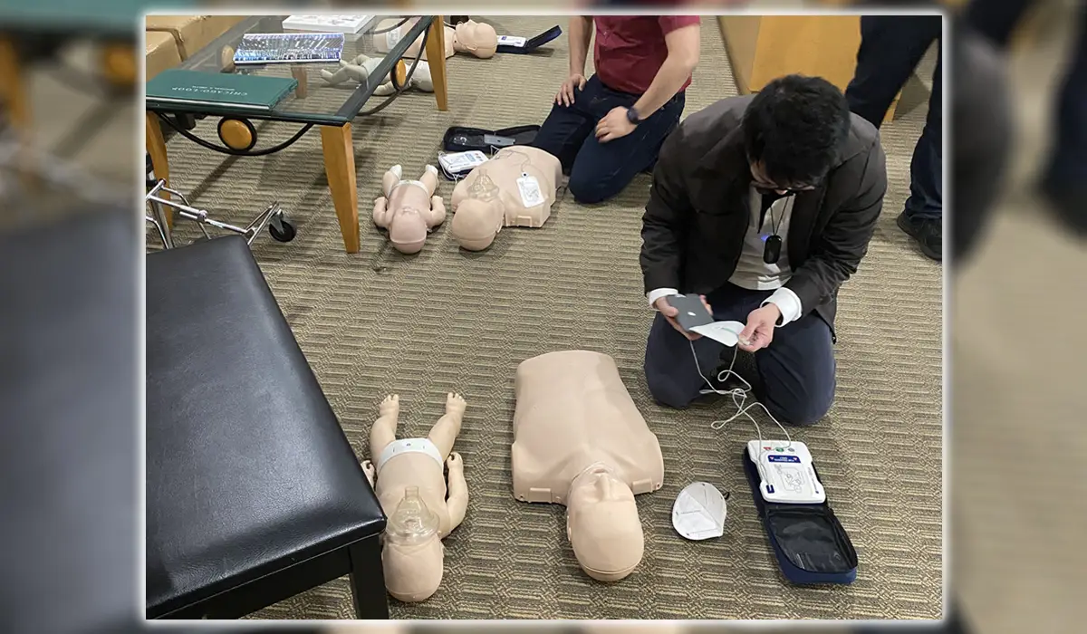A man holding an AED during training in ACLS.