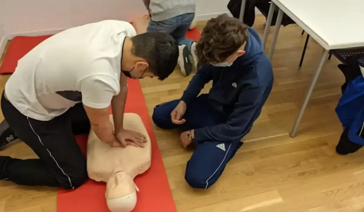 Two participants practicing chest compressions during a CPR training session as part of CPR certifications for construction workers.