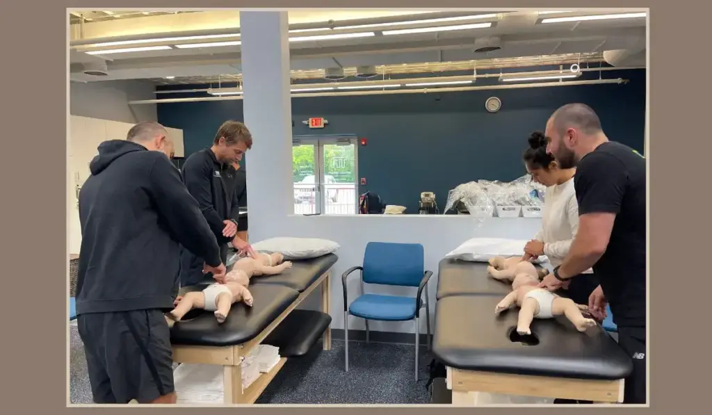 Healthcare providers practicing emergency techniques on infant mannequins during a neonatal resuscitation program training session.