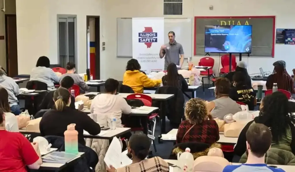 Instructor teaching a group of students during a CPR and ACLS Certification class in Chicago with mannequins for hands-on practice.