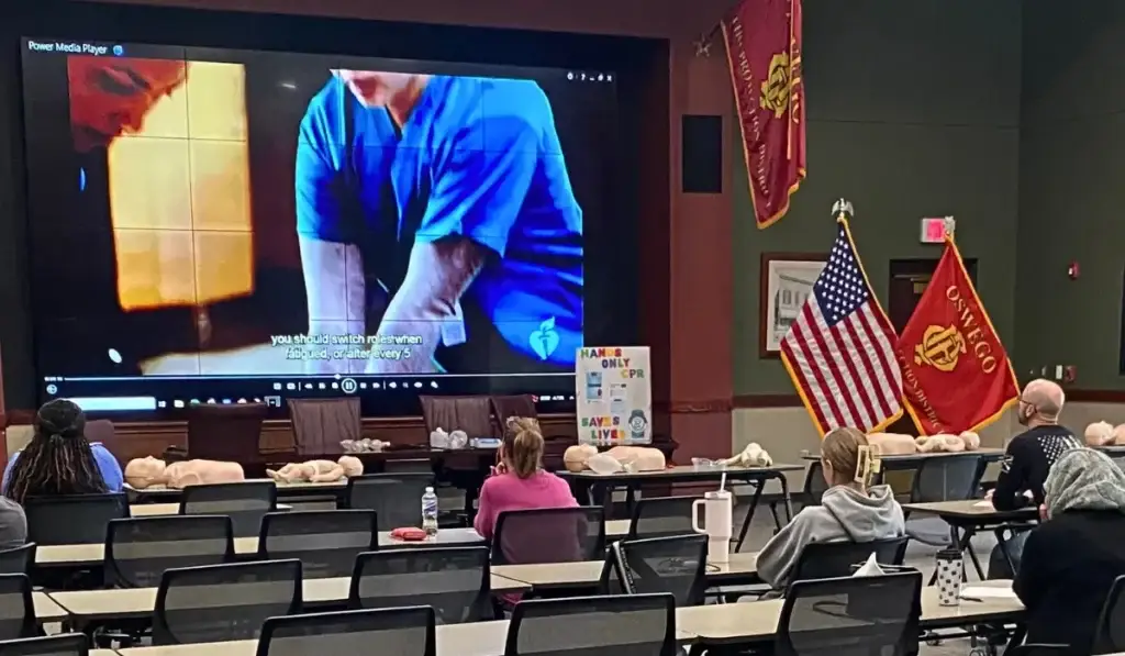 Classroom watching CPR video and mannequins for hands-only training promoting strong workplace safety culture awareness.
