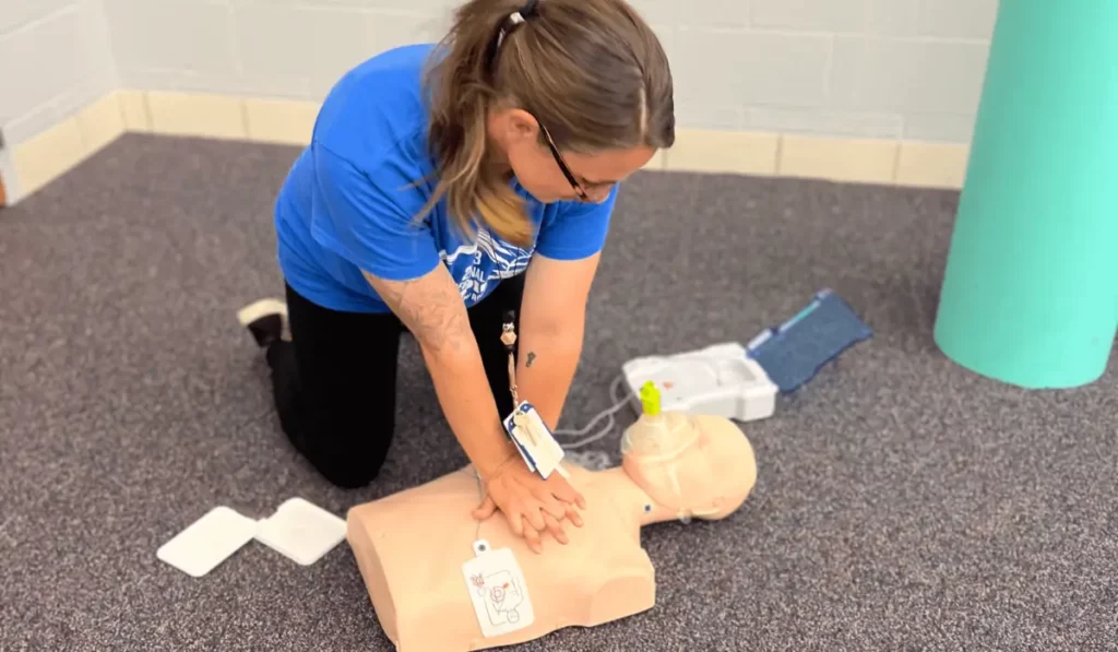 Student practicing chest compressions on a manikin during a CPR course in Chicago with hands-on training led by certified instructors.