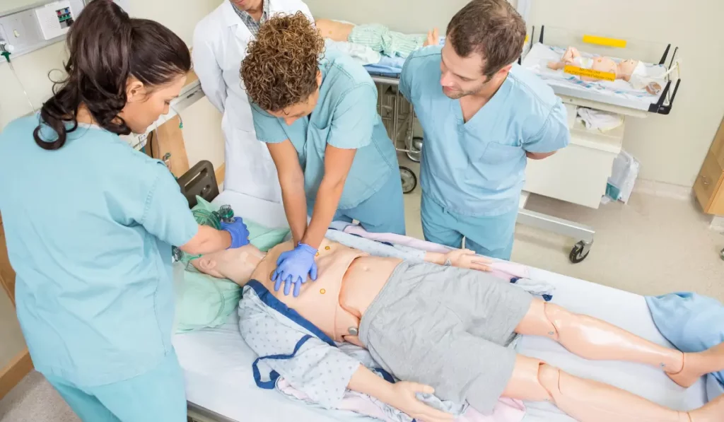Medical professionals performing CPR on a manikin during an ACLS class practice session focused on teamwork and emergency care.