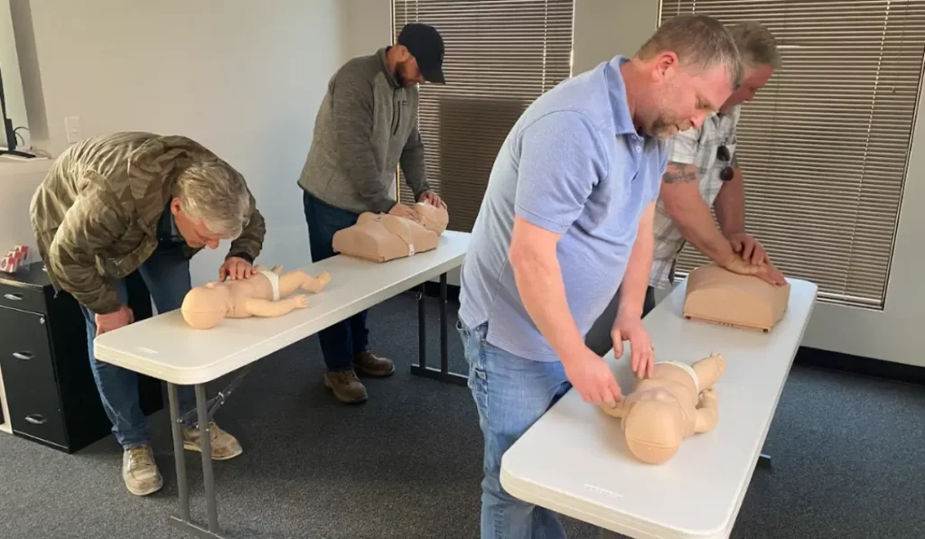Healthcare providers practicing CPR and pediatric assessment skills during a 2025 PALS Renewal Checklist training session.