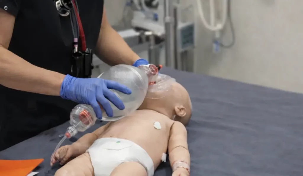 PALS certification for pediatric hospital airway simulation with infant manikin.