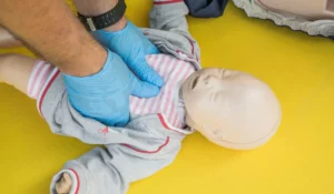 NRP Certification in Chicago training showing neonatal chest compressions on a newborn mannequin