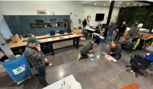 Employees complete CPR and OSHA compliance training through hands-on emergency response practice using adult manikins together.